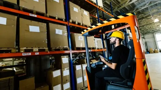 Warehouse industry worker doing logistics work with forklift loader