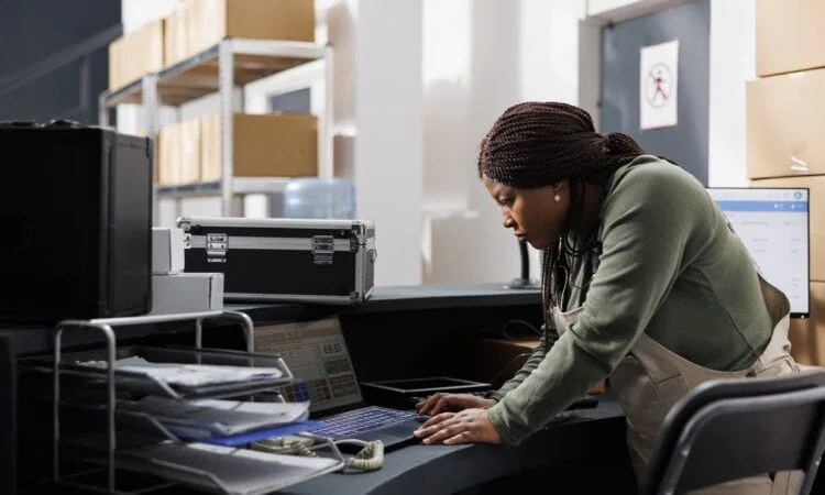 storehouse manager analyzing goods logistics on laptop